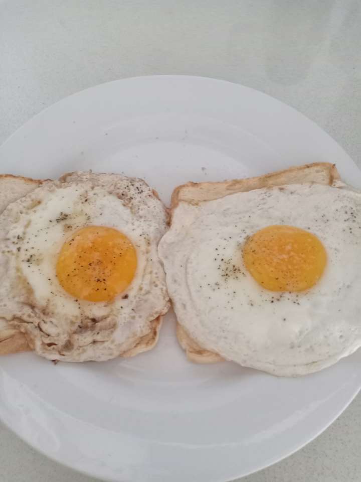 Half of a fried egg with bread